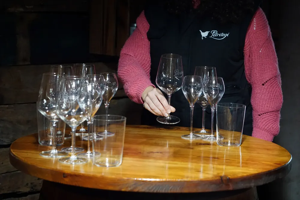 Tasting glasses set out on a barrel table in the Petritegi cellar