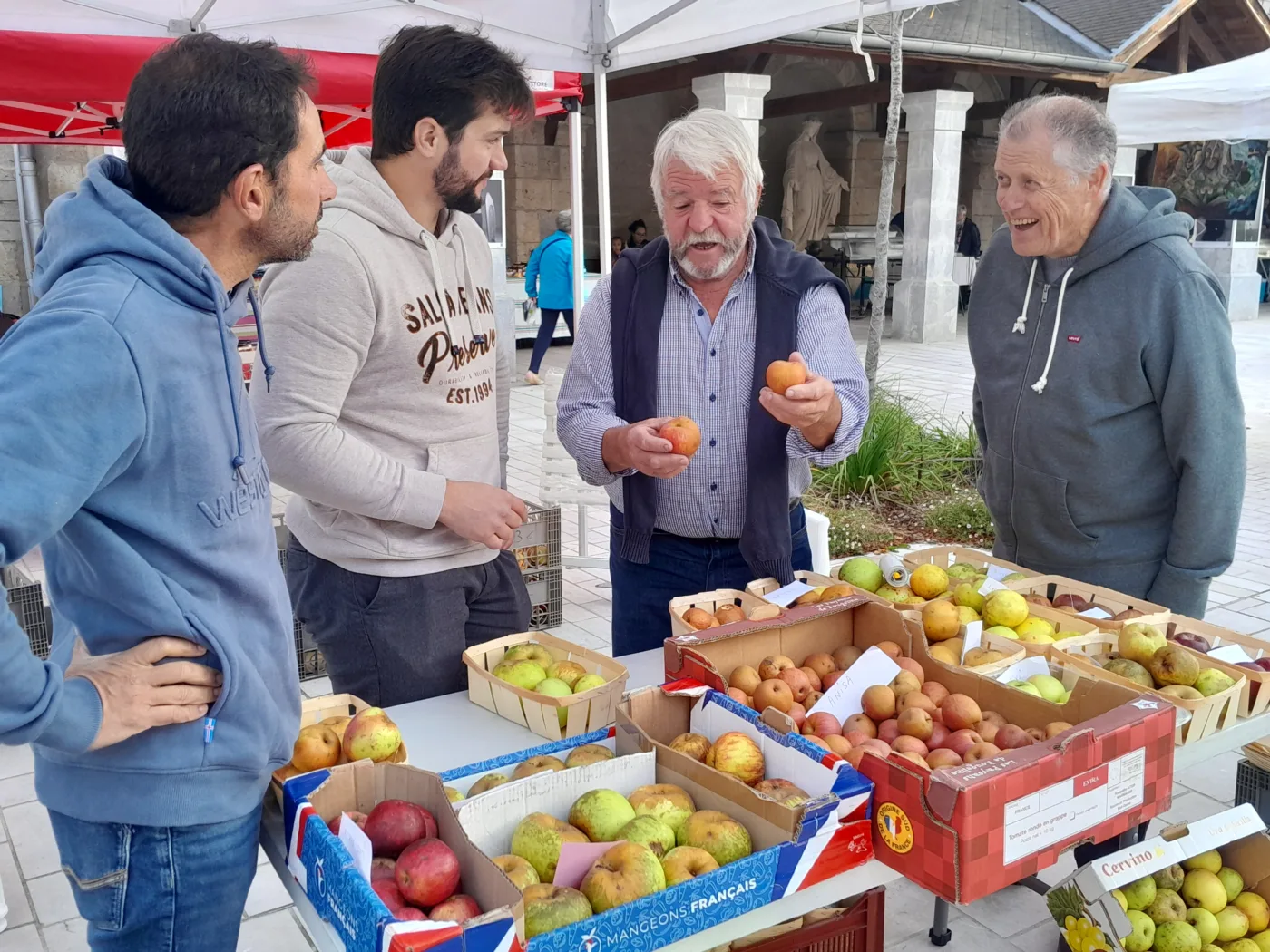 Gabriel Durruty, de Sagartzea, présente des variétés de pommes devant des cagettes au marché d’Hasparren