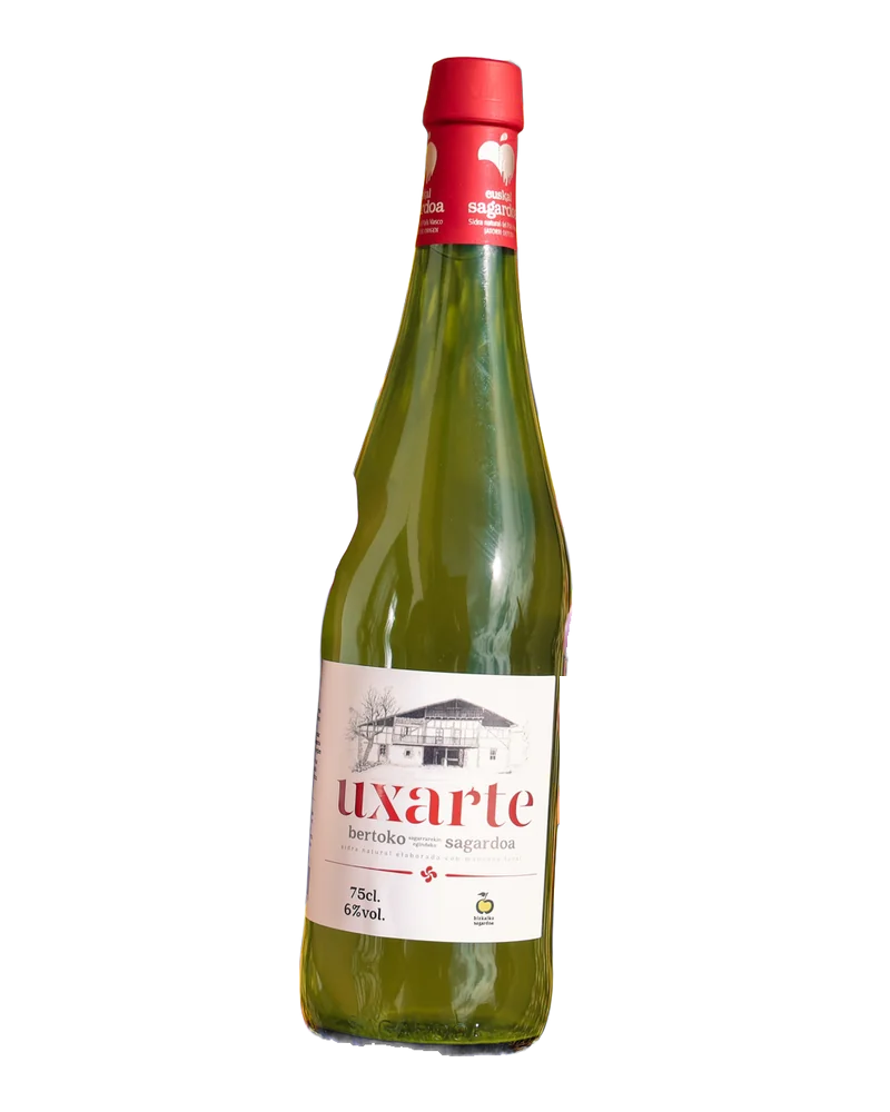 Botella verde de sidra natural Uxarte, con cápsula roja de la DO y etiqueta blanca con el dibujo del caserío
