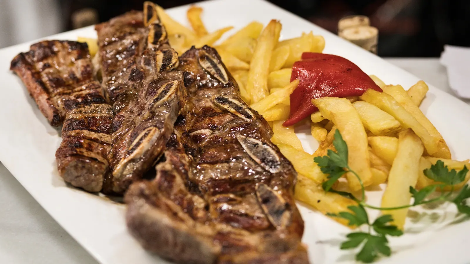 Plato de carne a la parrilla con patatas fritas y pimiento