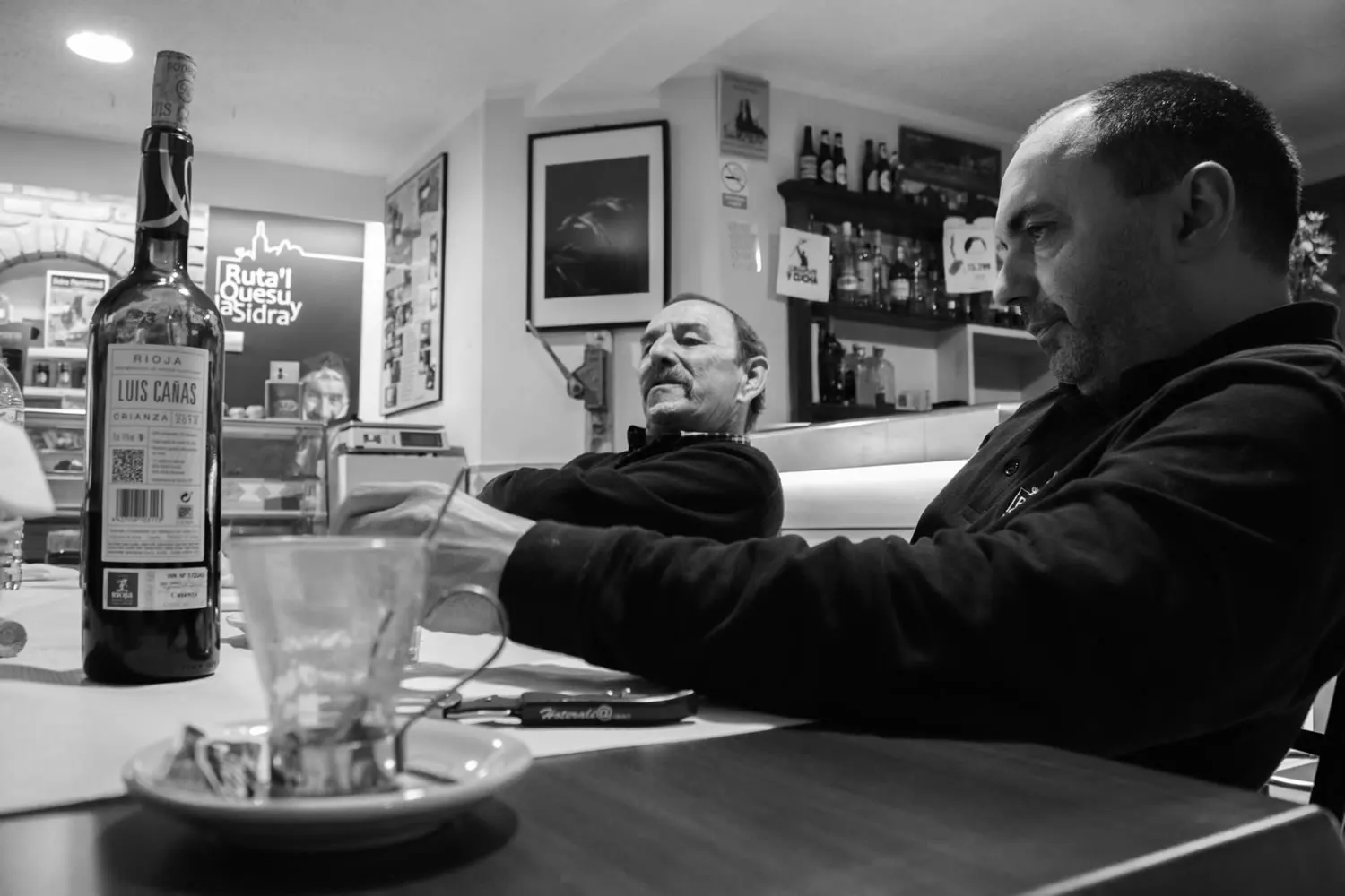 Barra del chigre de Casa Niembro con una botella de sidra y clientes