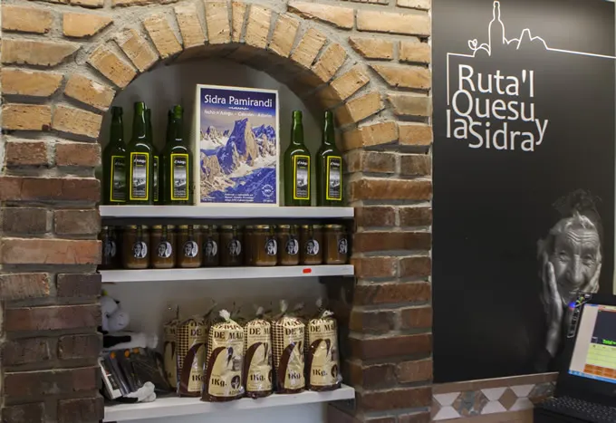 Estantería con botellas de Sidra Pamirandi bajo un arco de ladrillo