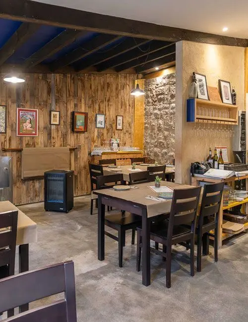 Dining room with wooden tables and a stone wall
