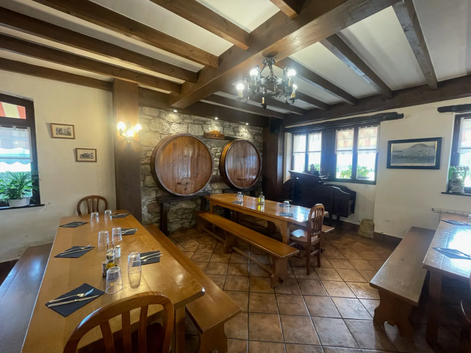 Comedor de la sidrería Oilurta Azpi, con kupelas de madera, mesas corridas con bancos y vigas en el techo