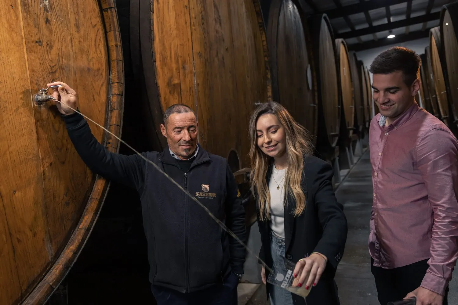 Txotx en la sidrería Saizar, con el chorro de sidra saliendo de una kupela hacia el vaso