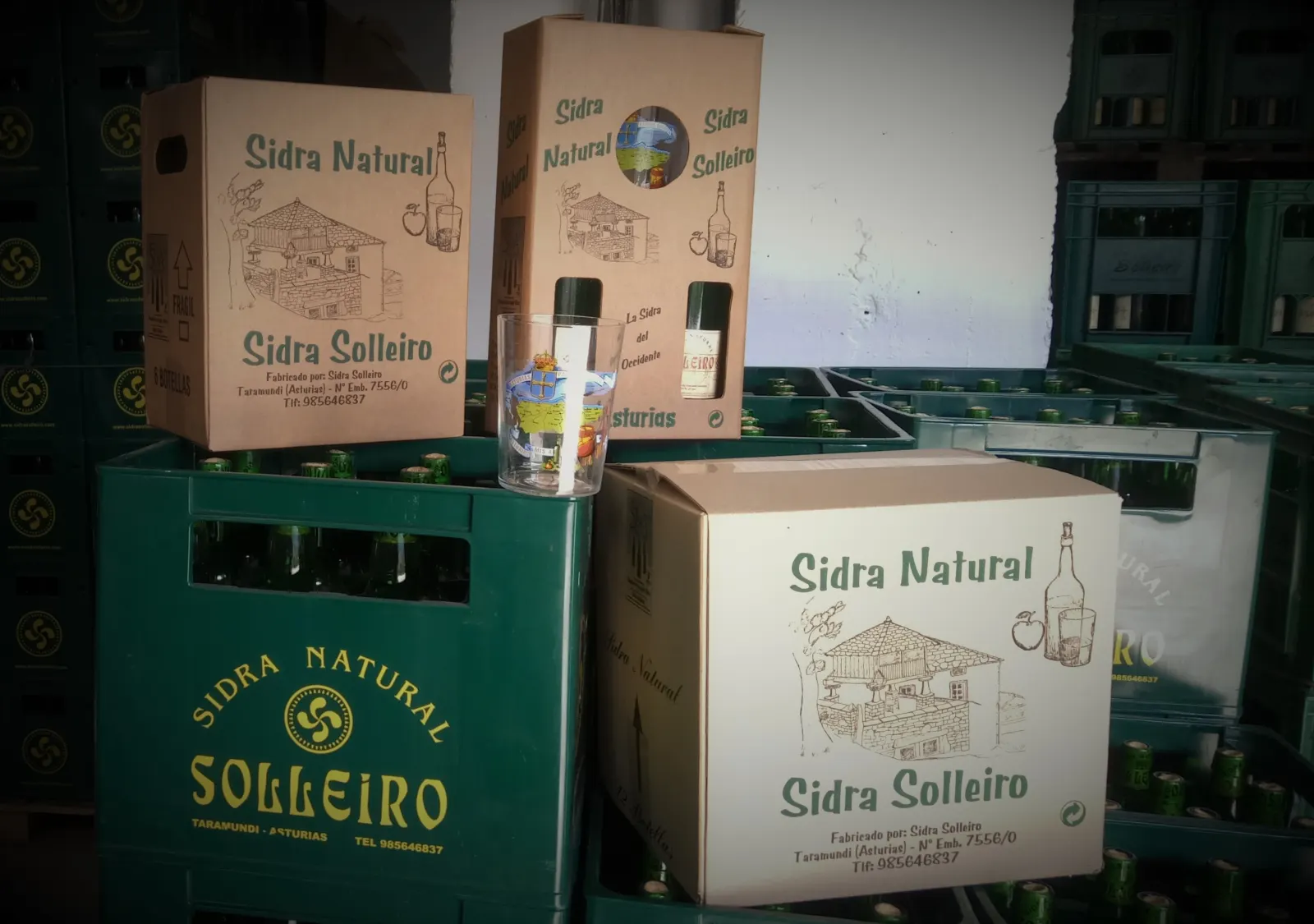 Boxes and a gift case of Solleiro natural cider on crates of bottles