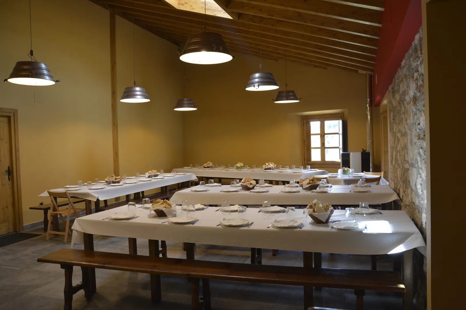 Comedor de la sidrería Trebiñu con mesas largas y bancos de madera